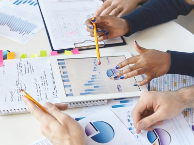 colleagues-working-together-financial-report-using-modern-gadget